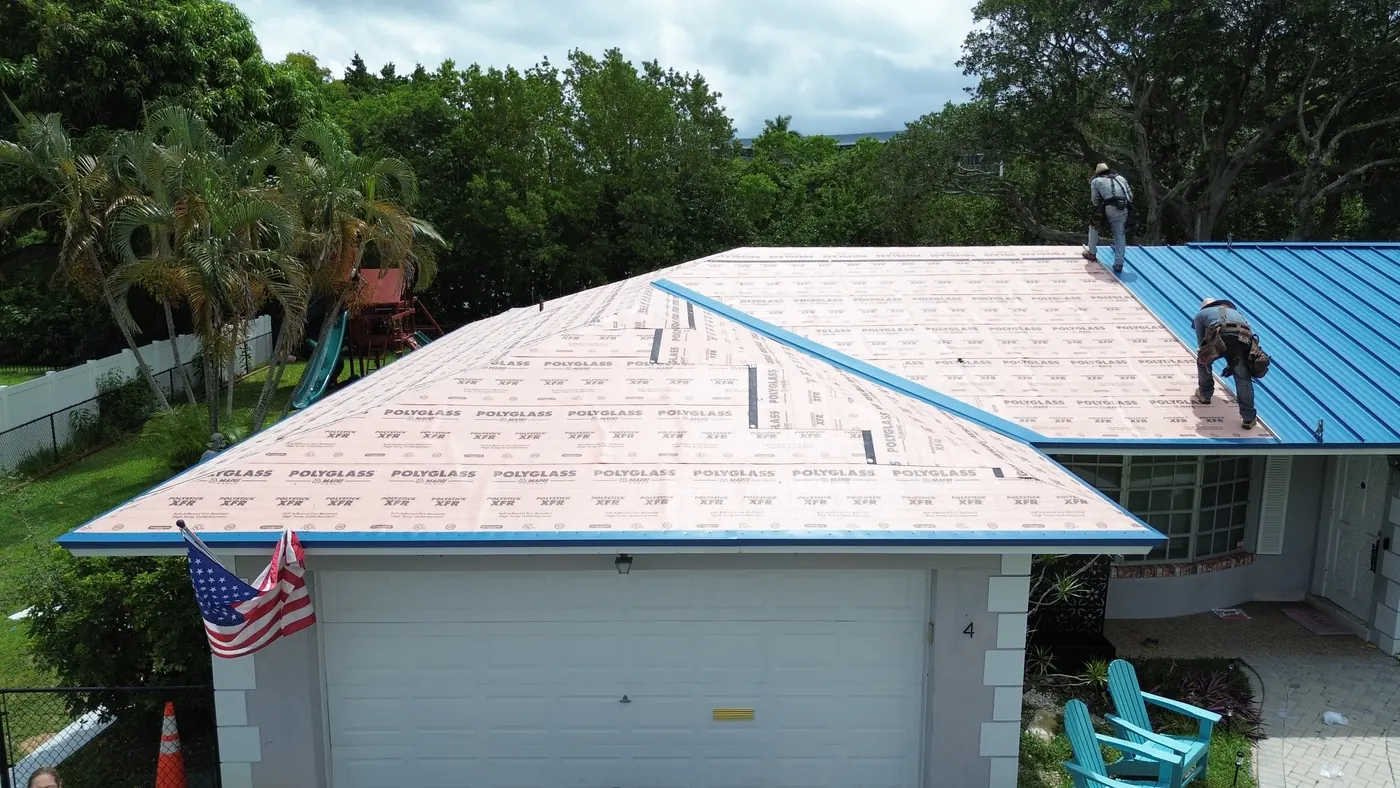 Standing-seam panels going on over fresh underlayment